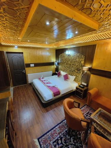 a bedroom with a bed and a couch and a chair at Hotel Gulmarg Lux Shanum in Gulmarg