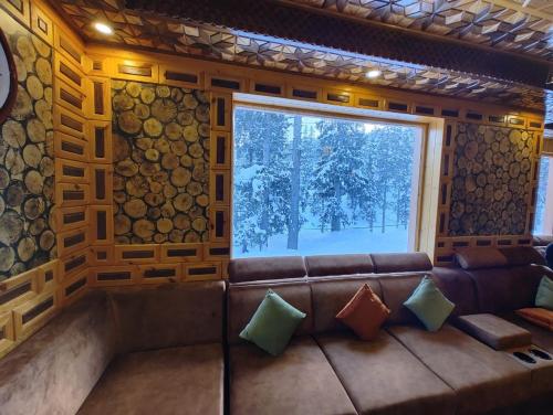 a living room with a couch and a window at Hotel Gulmarg Lux Shanum in Gulmarg