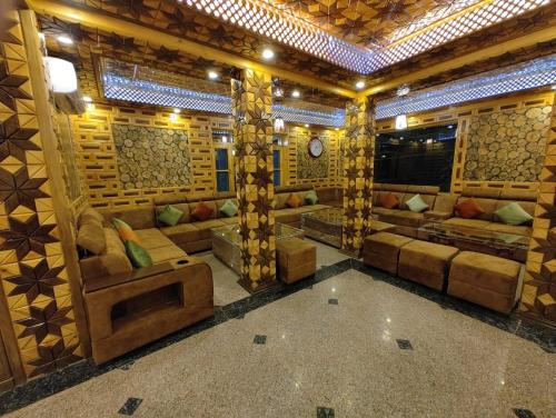 a large room with couches and a clock on the wall at Hotel Gulmarg Lux Shanum in Gulmarg