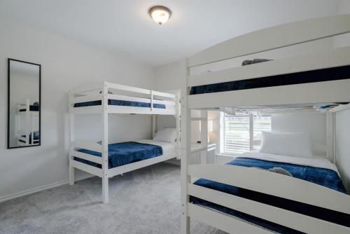 a bedroom with two bunk beds and a mirror at Vibrant Spacious Home w Private Pool and Jacuzzi in Richardson