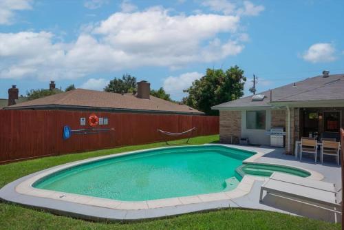 a swimming pool in the backyard of a house at Vibrant Spacious Home w Private Pool and Jacuzzi in Richardson