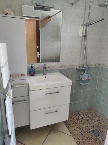 une salle de bain avec un lavabo blanc et un miroir dans l'établissement La Maison De La Mer, Villa duplex 150m de la plage, à Marseillan