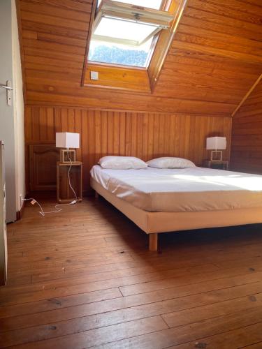 une chambre avec un lit et une lucarne dans l'établissement Studio luchon, à Luchon
