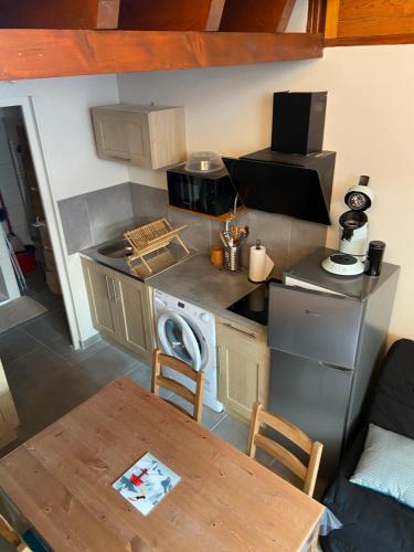 une petite cuisine avec une table et une cuisinière dans l'établissement Studio luchon, à Luchon