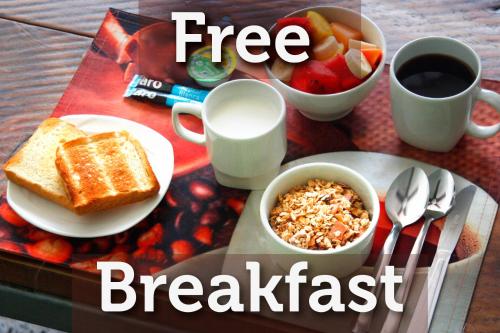 a breakfast table with toast and a bowl of fruit and milk at La Guaca Hostel Santa Marta in Santa Marta