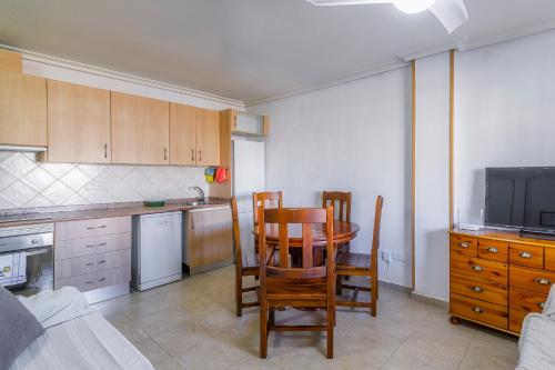 a kitchen with a table and two chairs and a television at Adosado Los Alcazares Rio Esla in Los Alcázares