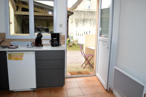 une cuisine avec un évier et un plan de travail dans l'établissement Chez Fabienne, maison avec petite terrasse privée, à Luc-sur-Mer