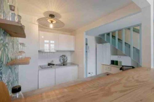 une cuisine avec des placards blancs et un escalier dans l'établissement Beau studio duplex plein centre, à Aix-en-Provence