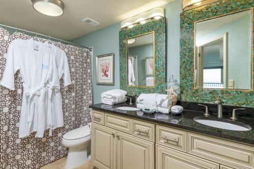 Un baño con dos lavabos, un inodoro y un espejo. en The Palms 1001, en Orange Beach