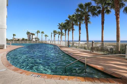 einen Pool neben einem Strand mit Palmen in der Unterkunft Turquoise Place 705C in Orange Beach