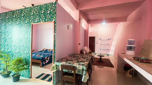 una piccola camera con un tavolo e un letto di Aizawl Homestay ad Āīzawl