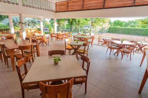 an empty restaurant with wooden tables and chairs at GHL Hotel Club el Puente in Girardot