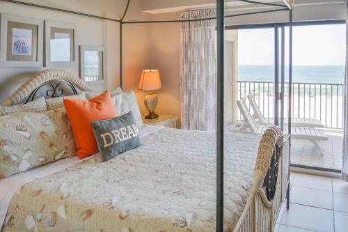 a bedroom with a bed and a balcony with the ocean at The Palms 314 in Orange Beach