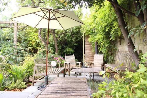 a patio with an umbrella and a table and chairs at ※ Relaxing Home- Parking & Gorgeous Gardens (TSG)※ in Bath