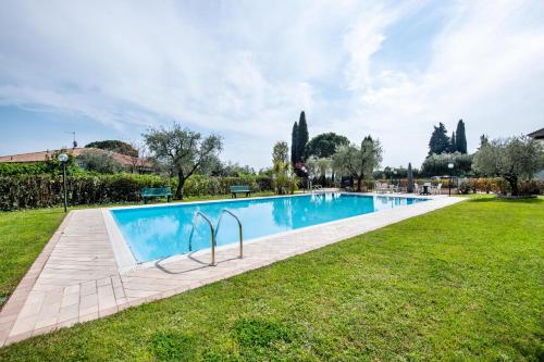 a swimming pool in a yard with grass at Appartamento Colibri in San Felice del Benaco