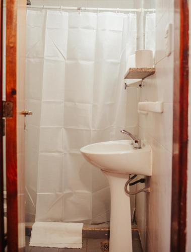 ein weißes Bad mit einem Waschbecken und einer Dusche in der Unterkunft HOTEL REALICO in Realicó
