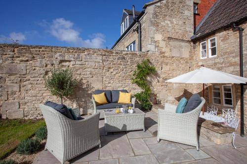 a patio with two chairs and an umbrella at ※ Charming Country House Nr Bath (WC)※ in Biddlestone