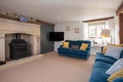 a living room with a blue couch and a fireplace at ※ Charming Country House Nr Bath (WC)※ in Biddlestone