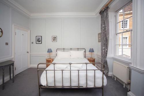 a white bedroom with a bed and a window at The Georgian Townhouse @ Pierrepont Place in Bath