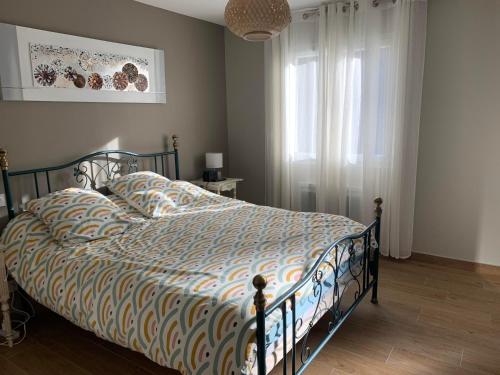 une chambre avec un lit avec une couette et une fenêtre dans l'établissement VILLA A LA RIVIERE, à Saint-Jean-du-Bruel