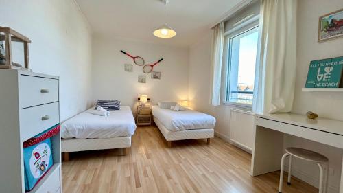 a small room with two beds and a desk at Pointe de Sel, appartement face au port du Crotoy in Le Crotoy