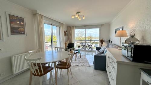 une cuisine et un salon avec une table et des chaises dans l'établissement Pointe de Sel, appartement face au port du Crotoy, au Crotoy