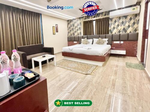 a bedroom with a bed and a couch and a table at Hotel Yashasvi inn ! Puri near-sea-beach-and-temple fully-air-conditioned-hotel with-lift-and-parking-facility breakfast-included in Puri