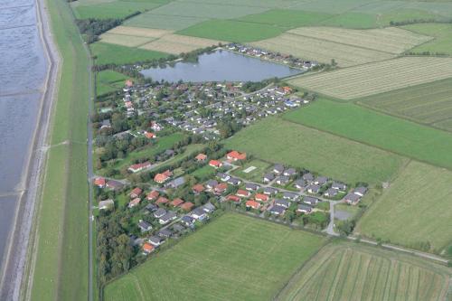 布特亚丁根E13 Ferienhaus mit Garten, Terrasse und Deichblick的享有村庄的空中景色,享有河流和田野