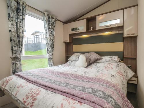 a bedroom with a large bed and a window at 47 The Drake Forgetmeknot in Scarborough