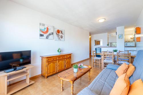 un soggiorno con divano blu e tavolo di Basic Comfort Apartment Gran Reserva 0073 a Empuriabrava