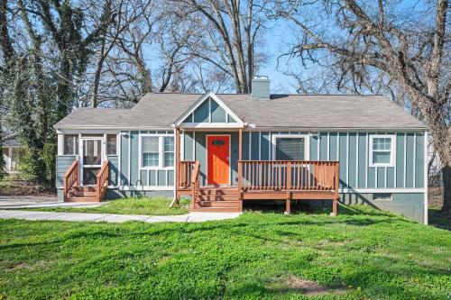 a small blue house with a porch and orange door at Relax in a Modern Luxury 1BD in Sylvan Hills in Atlanta