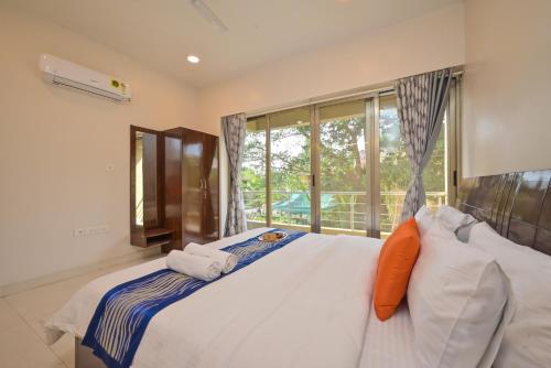1 dormitorio con 1 cama blanca grande y ventana en Villa Furama 3 bhk en Lonavala