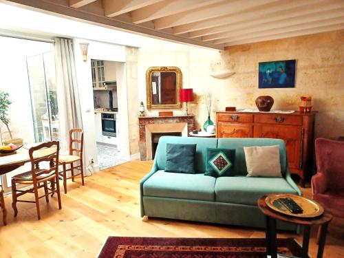 un salon avec un canapé bleu et une table dans l'établissement L'échoppe sur la place, à Bordeaux