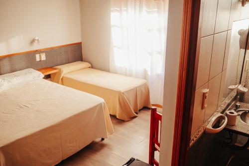 Cette petite chambre comprend 2 lits et une fenêtre. dans l'établissement HOTEL REALICO, à Realicó