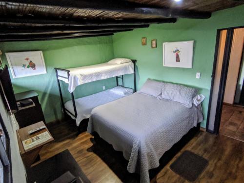 1 dormitorio con 2 literas y una pared verde en Posada Cafe La Huerta en Guasca