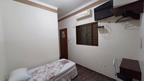 a small room with a bed and a window at HOTEL TABARANA in Ubarana