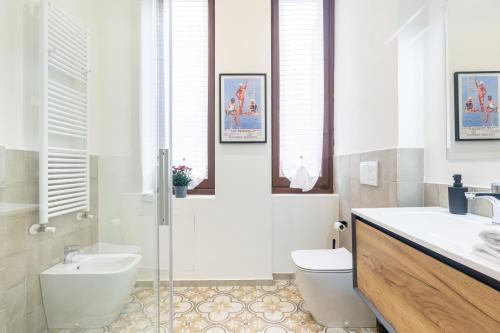 a bathroom with a toilet and a sink and a shower at Borgo Bliss in Parma's San Giuseppe District in Parma