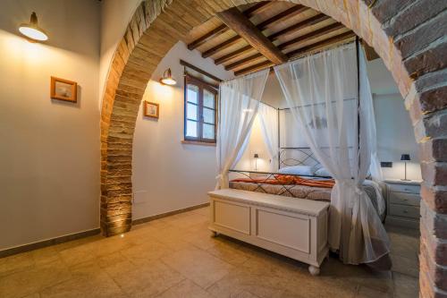 a bedroom with a canopy bed with white curtains at Agriturismo - La Campagna di San Francesco in Tordandrea