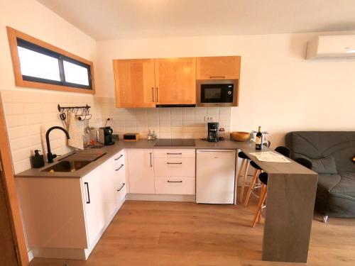 a small kitchen with a sink and a microwave at Arimar Sun 13 Puerto Rico in Puerto Rico de Gran Canaria