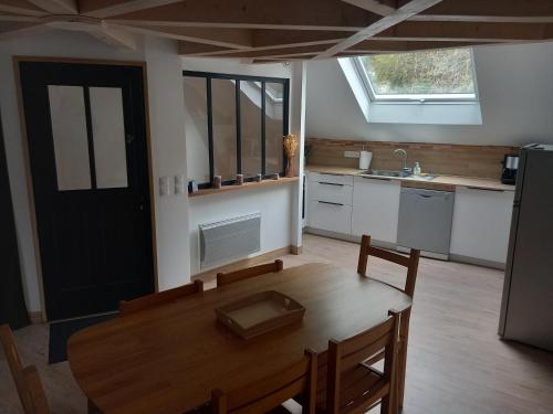 une cuisine avec une table en bois et une salle à manger dans l'établissement La grange, à Nazelles-Négron