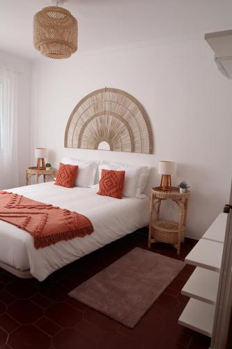 a bedroom with a large white bed with red pillows at Wild Blue By SVL in Ponta Delgada