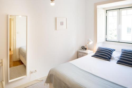 una camera bianca con un letto e una finestra di Apartment in Lisbon city center with a terrace, 317 a Lisbona