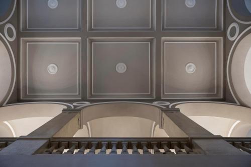 an ornate room with a staircase and mirrors at Grand Hotel di Parma | UNA Esperienze in Parma