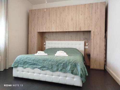 1 dormitorio con 1 cama blanca con manta verde en Casa Aris Fiera Vicenza, en Vicenza