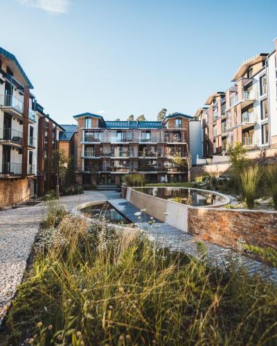 a row of apartment buildings with two ponds at MOLO LIPNO RESIDENCE in Lipno nad Vltavou