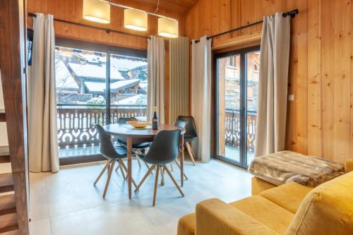 un salon avec une table et des chaises et un balcon dans l'établissement Efanle 3, à Morzine