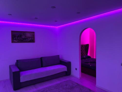 uma sala de estar com um sofá e iluminação rosa em Апартаменты Бульвар Славы 21 em Dnipro