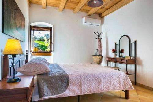 a bedroom with a bed and a table and a mirror at 1841 Petrino Villa in Fiskardho