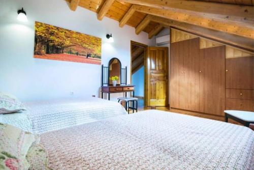 a bedroom with a large white bed and wooden ceilings at 1841 Petrino Villa in Fiskardho