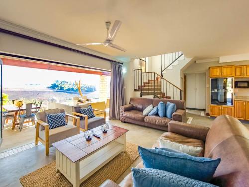 ein Wohnzimmer mit Sofa und Tisch in der Unterkunft Shiloh Cottage in Champagne Valley